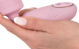 Kleine Grafik zum Thema Vibrator mit einer Frauenhand, die einen kleinen, rosanen Vibrator hält